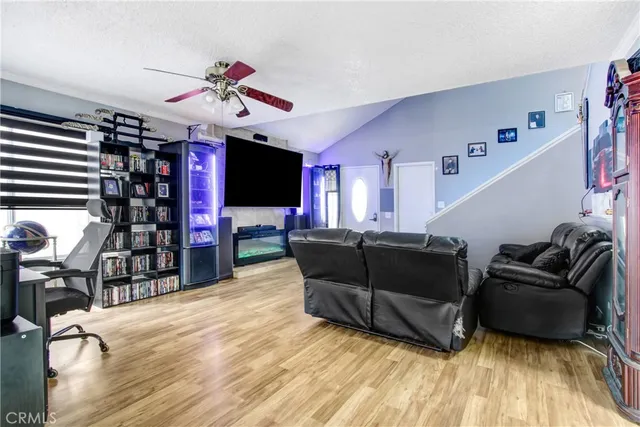 a living room with furniture a flat screen tv and kitchen view