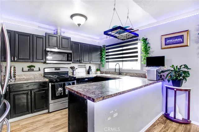 a kitchen with stainless steel appliances granite countertop a stove sink and microwave
