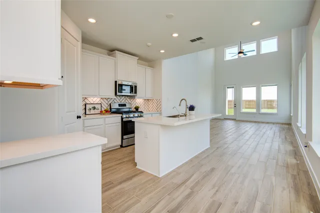a kitchen with stainless steel appliances a sink stove and microwave