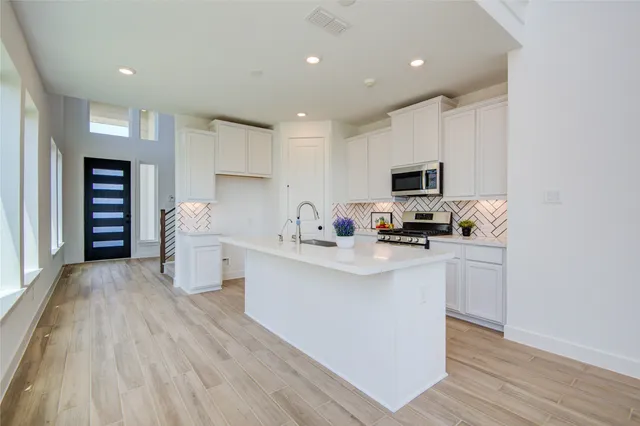 a kitchen with stainless steel appliances a stove microwave and cabinets