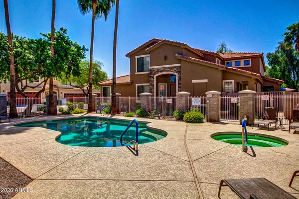 a front view of a house with garden and trees
