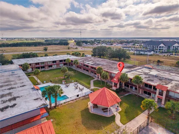 an aerial view of a swimming pool with outdoor seating