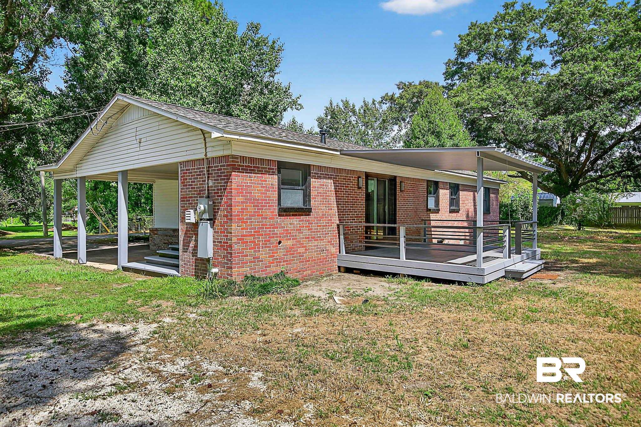 101 Terry Avenue Brewton, AL 36426 - Photo 4 of 48 View of side of property with a lawn, brick siding, and a wooden deck