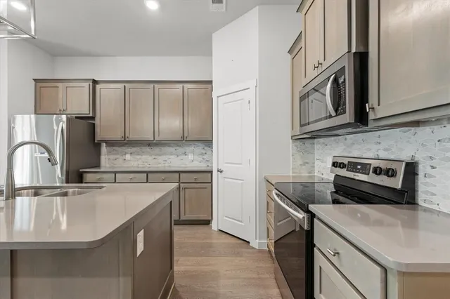 a kitchen with stainless steel appliances granite countertop a sink stove and refrigerator