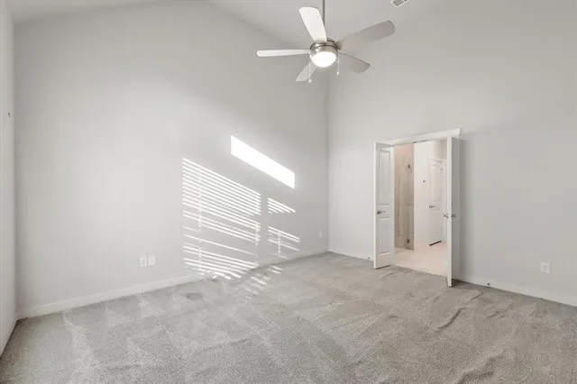 an empty room with a ceiling fan and window