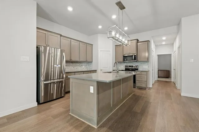 a kitchen with kitchen island granite countertop a stove refrigerator and microwave