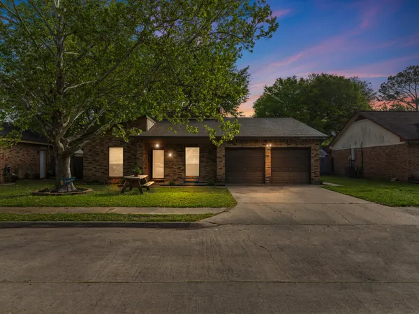 a front view of a house with a yard and trees