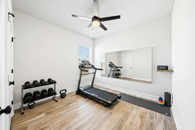 a room with gym equipment and wooden floor