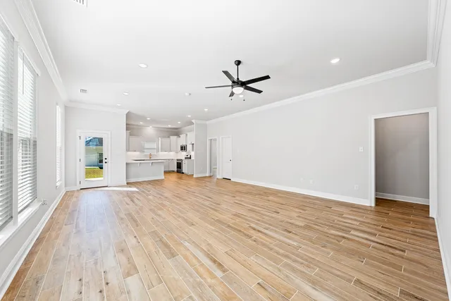 a view of empty room with wooden floor and window