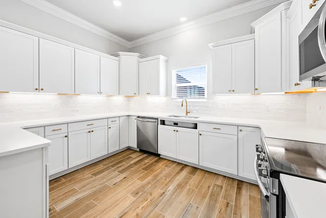 a kitchen with granite countertop white cabinets and white appliances