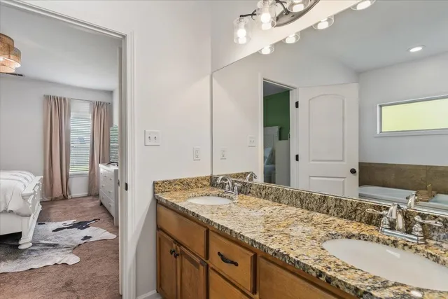 a bathroom with a granite countertop sink and a mirror