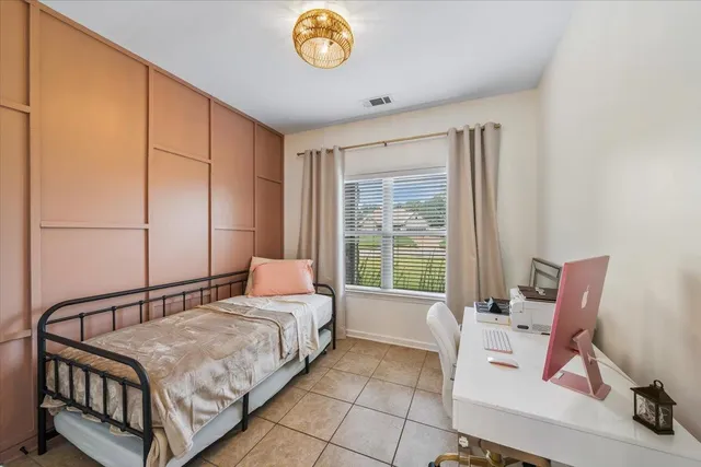 a bedroom with a bed chair and window