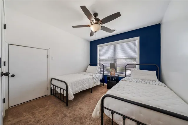 a bedroom with 2 bed and a window