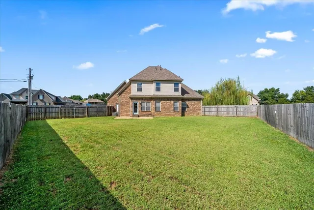 a view of a garden with a house in the background