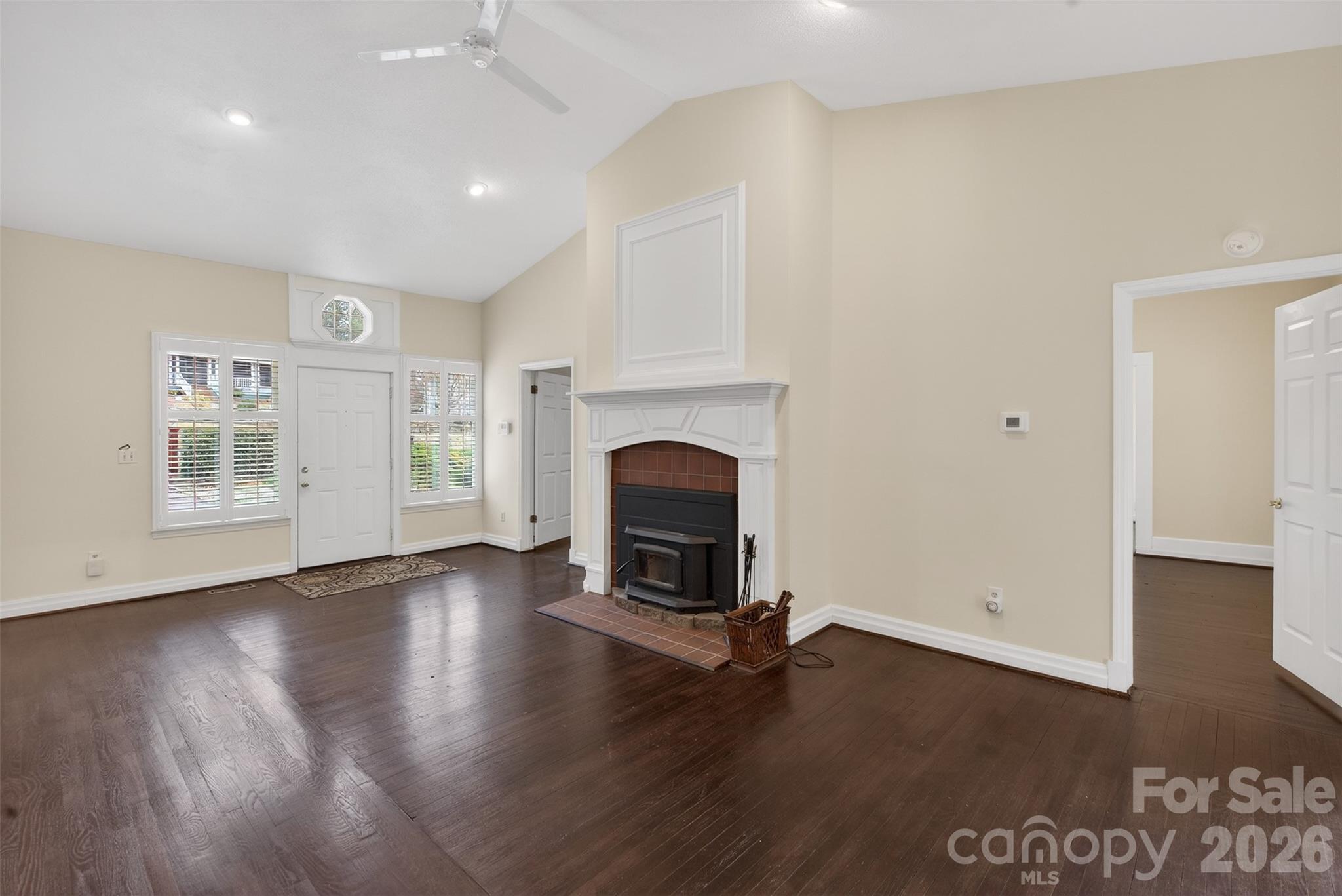 56 Whitney Avenue Tryon, NC 28782 - Photo 4 of 35 an empty room with fireplace wooden floor and windows