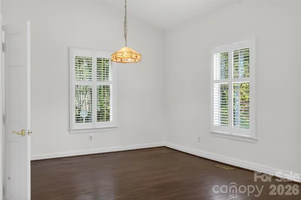 an empty room with wooden floor and window