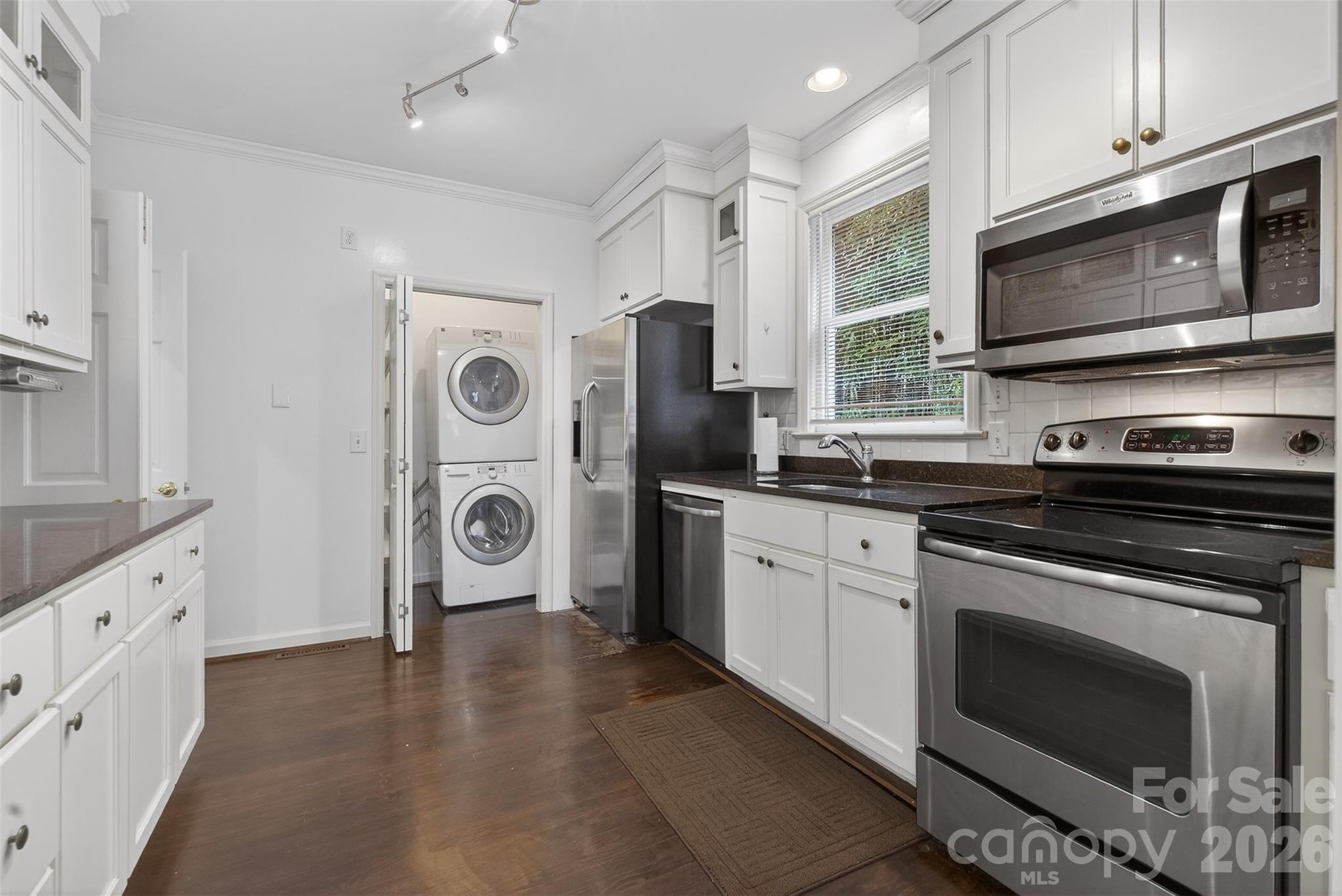 56 Whitney Avenue Tryon, NC 28782 - Photo 6 of 35 a kitchen with stainless steel appliances granite countertop a stove a microwave and a white cabinets