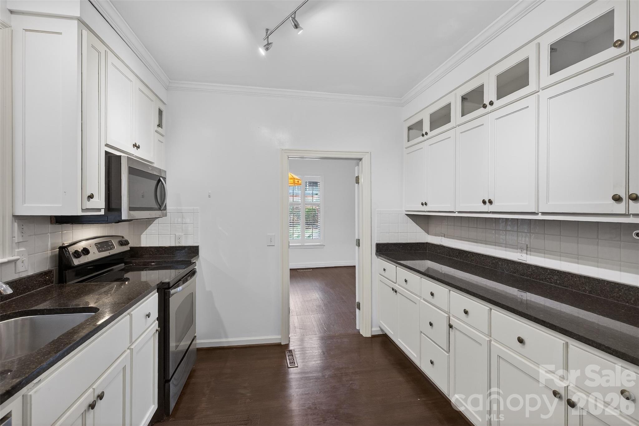 56 Whitney Avenue Tryon, NC 28782 - Photo 7 of 35 a kitchen with granite countertop white cabinets and stainless steel appliances