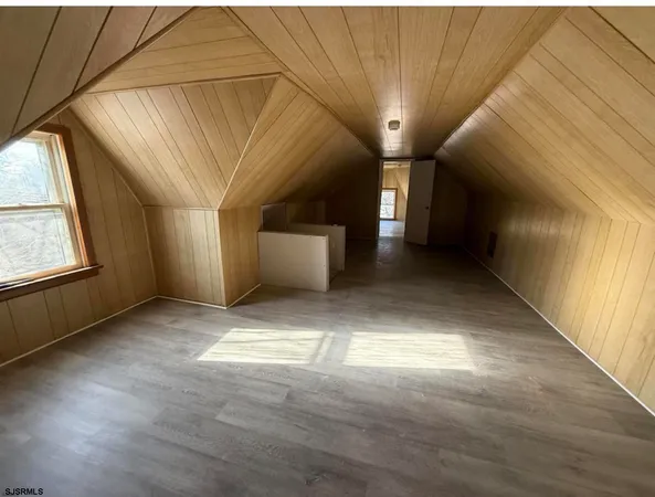 a view of a brick house with large windows and plants