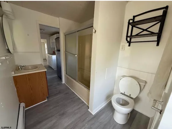 a large white kitchen with wooden floor