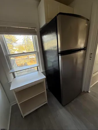 a kitchen with a refrigerator and a wooden floor