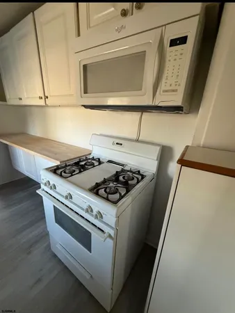 a kitchen with a refrigerator and a wooden floor
