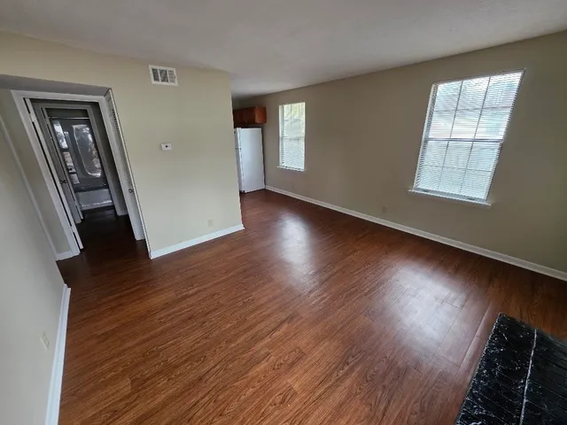 wooden floor in an empty room with a window