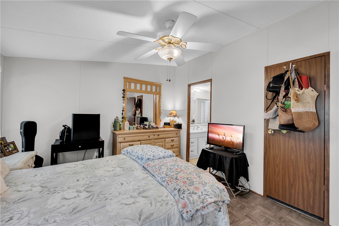 162 Newberry Road Walhalla, SC 29691 - Photo 16 of 50 A comforting bedroom with a ceiling fan, a glimpse of a bathroom, and wood-like flooring.