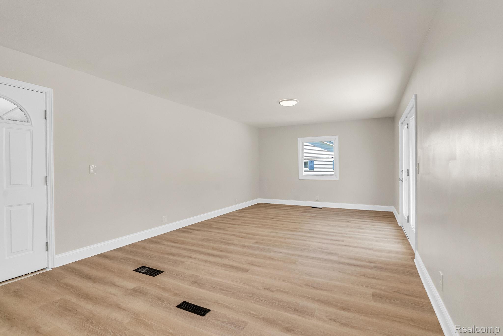 4046 State Road Fort Gratiot, MI 48059 - Photo 17 of 38 Spacious room featuring wood-finish flooring, light neutral wall paint, and white baseboards