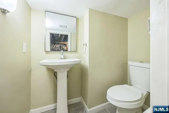 a bathroom with a sink toilet and a mirror
