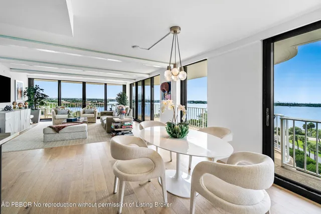 a kitchen with stainless steel appliances kitchen island granite countertop a dining table chairs and a stove