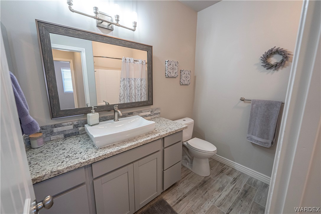 3550 North Kenneth Road Kingman, AZ 86409 - Photo 23 of 41 a bathroom with a granite countertop sink toilet and mirror