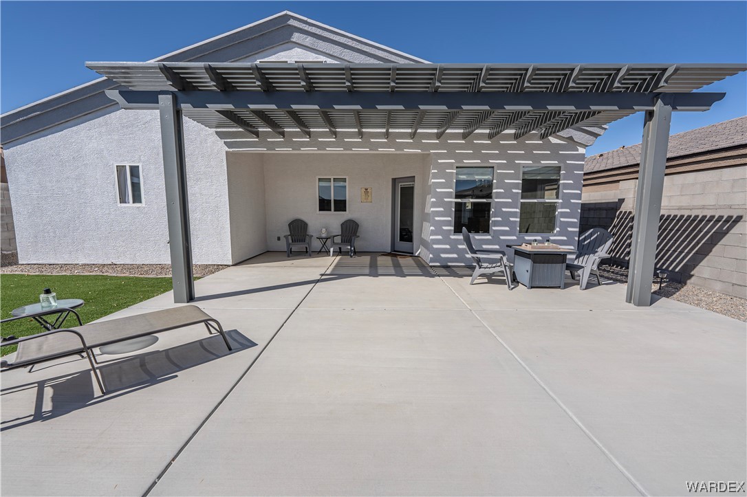 3550 North Kenneth Road Kingman, AZ 86409 - Photo 32 of 41 a view of a patio with table and chairs a barbeque with potted plants and floor to ceiling window