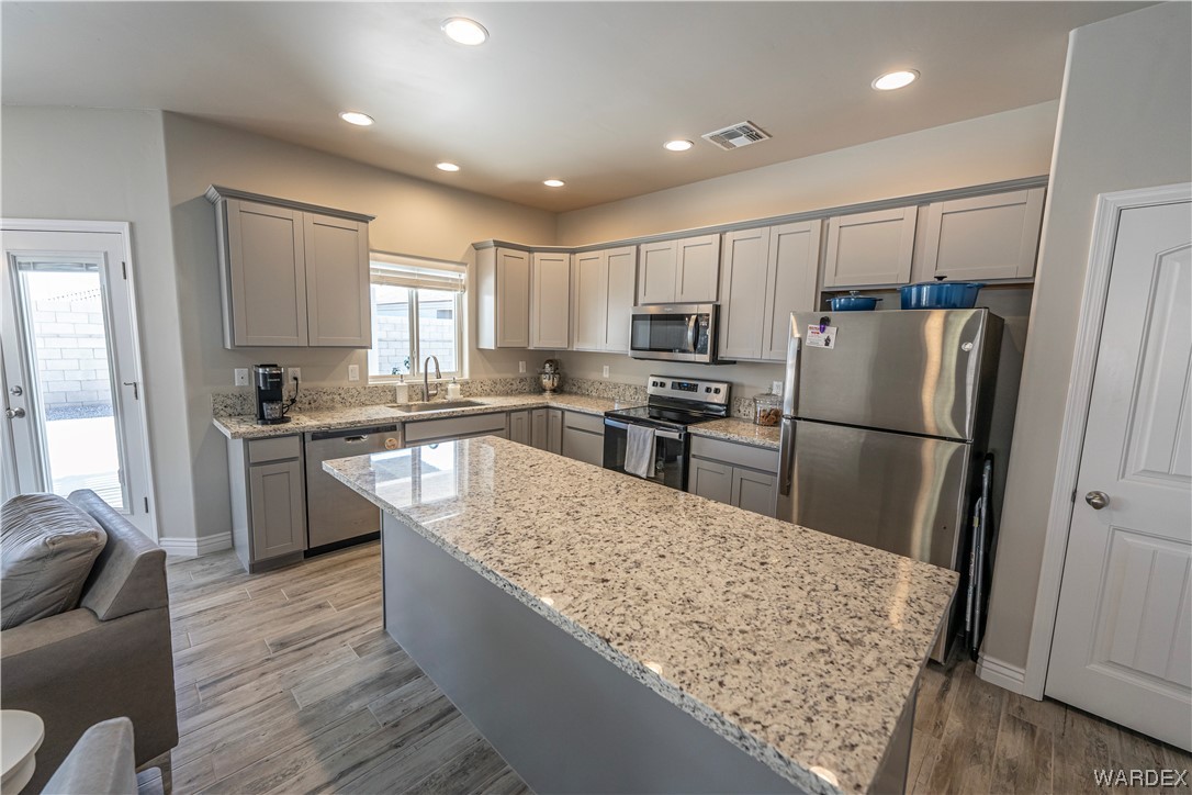 3550 North Kenneth Road Kingman, AZ 86409 - Photo 10 of 41 a kitchen with stainless steel appliances granite countertop a refrigerator a sink a stove a microwave and island