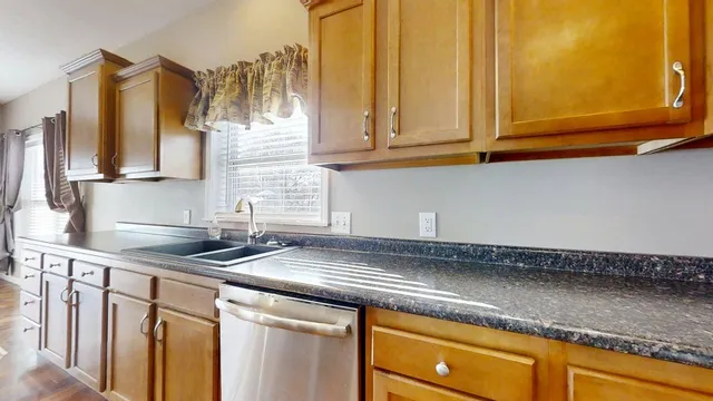 a kitchen with granite countertop a sink and cabinets