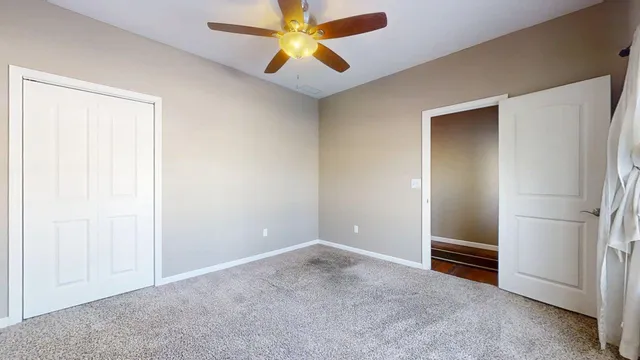 a view of an empty room with a ceiling fan