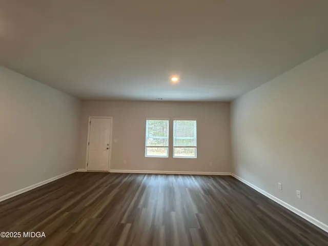 an empty room with wooden floor and window