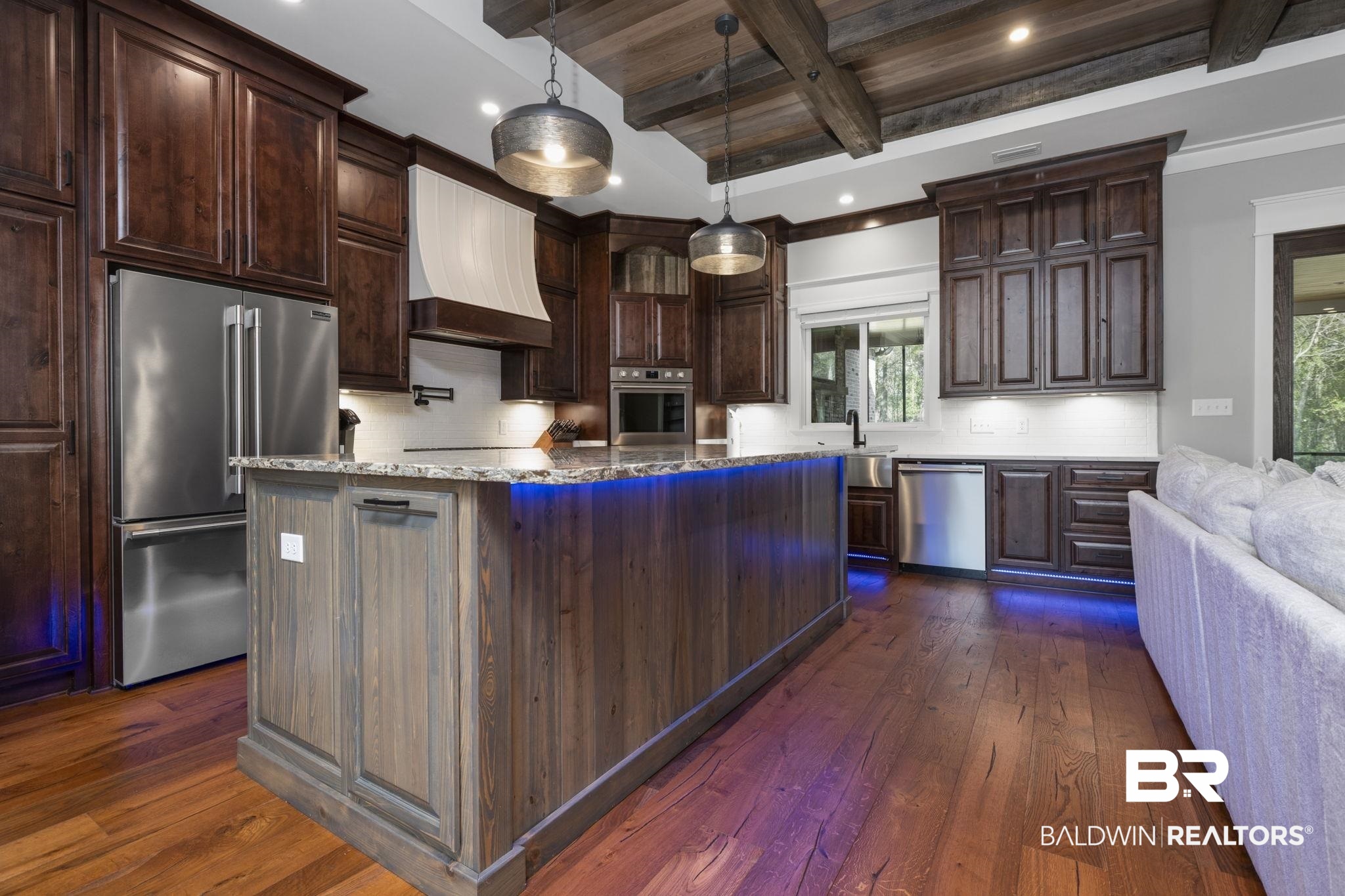 9501 Ben Hamilton Road Theodore, AL 36582 - Photo 21 of 69 Kitchen with stainless steel appliances, a wooden ceiling with exposed beams, dark wood-style floors, light stone counters, and a kitchen island