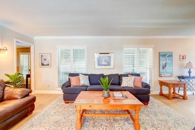 a living room with furniture a ceiling fan and a window