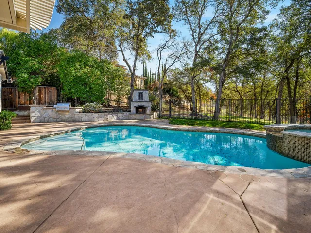 a kitchen with stainless steel appliances granite countertop a table chairs in it and wooden floors