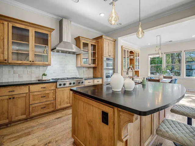 a kitchen with stainless steel appliances granite countertop a sink a stove and a refrigerator
