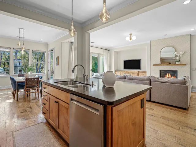 a dining area with stainless steel appliances kitchen island granite countertop a dining table chairs and a oven