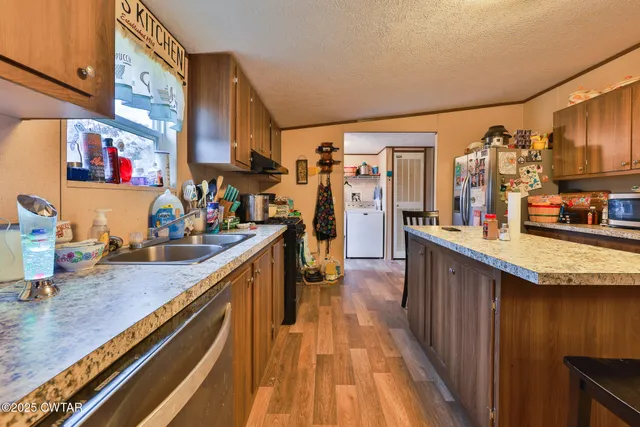a kitchen with stainless steel appliances granite countertop lots of counter top space and wooden floor