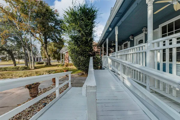 a view of a balcony with wooden floor and fence
