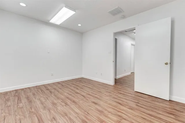 a view of an empty room with wooden floor