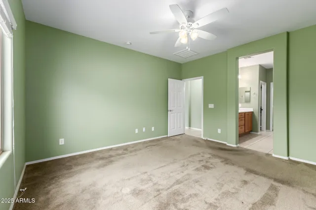 an empty room with a ceiling fan and a window