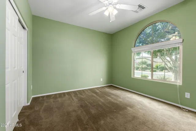 an empty room with a window and a chandelier