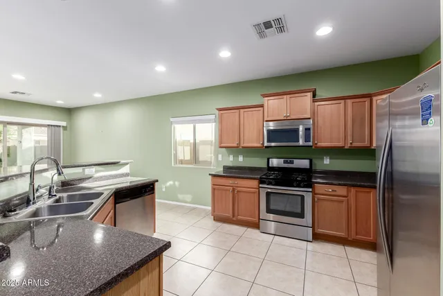 a kitchen with stainless steel appliances granite countertop a sink counter space cabinets and a large window