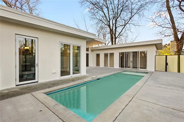 a view of an empty room with wooden floor and a bathroom