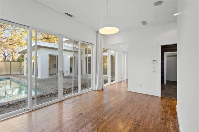 a view of an empty room with wooden floor
